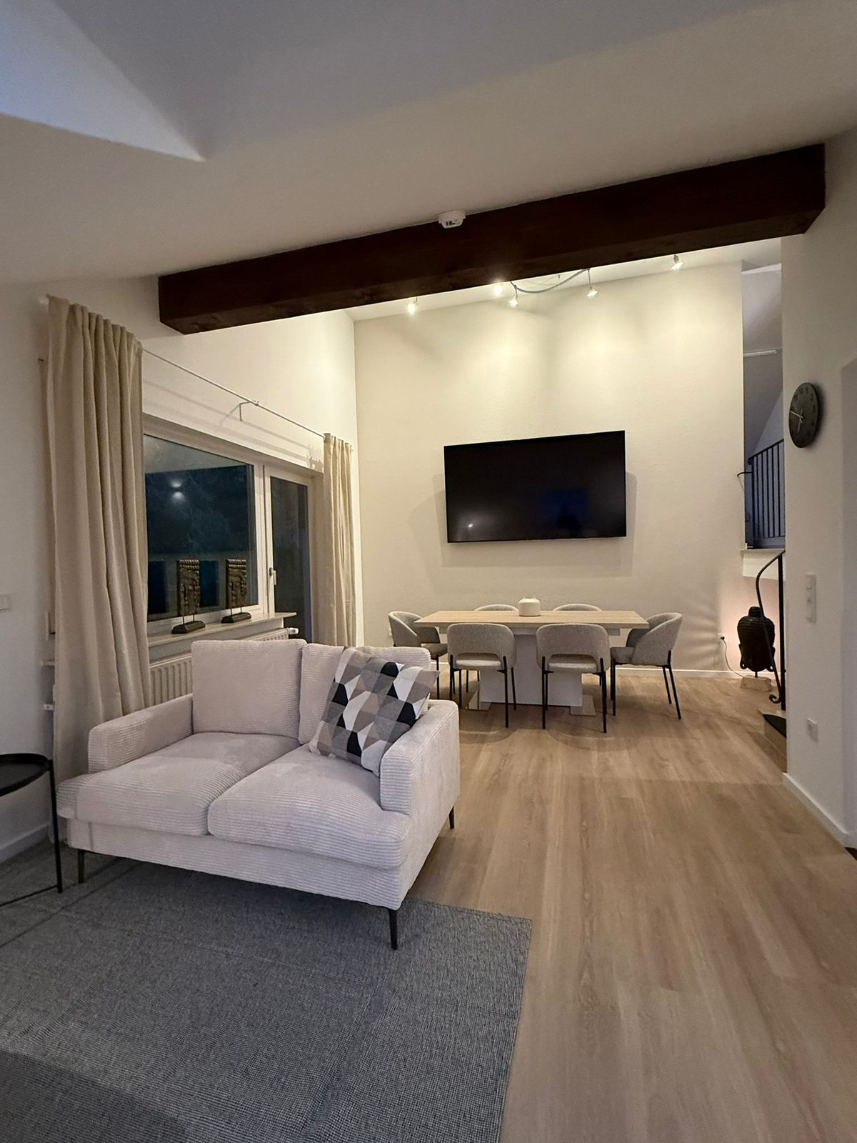 Wohnzimmer mit Holzbalken und Vinylboden nach Renovierung